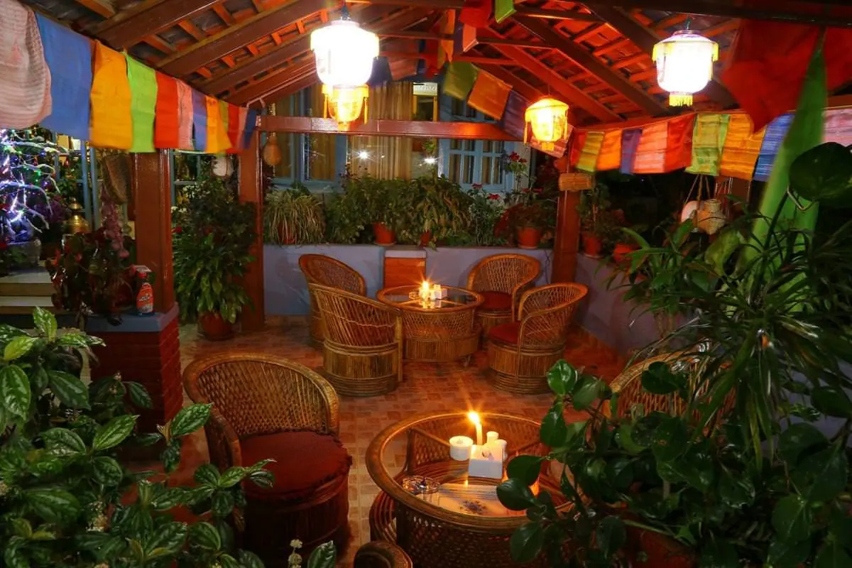Lantern-lit garden seating with prayer flags in the evening
