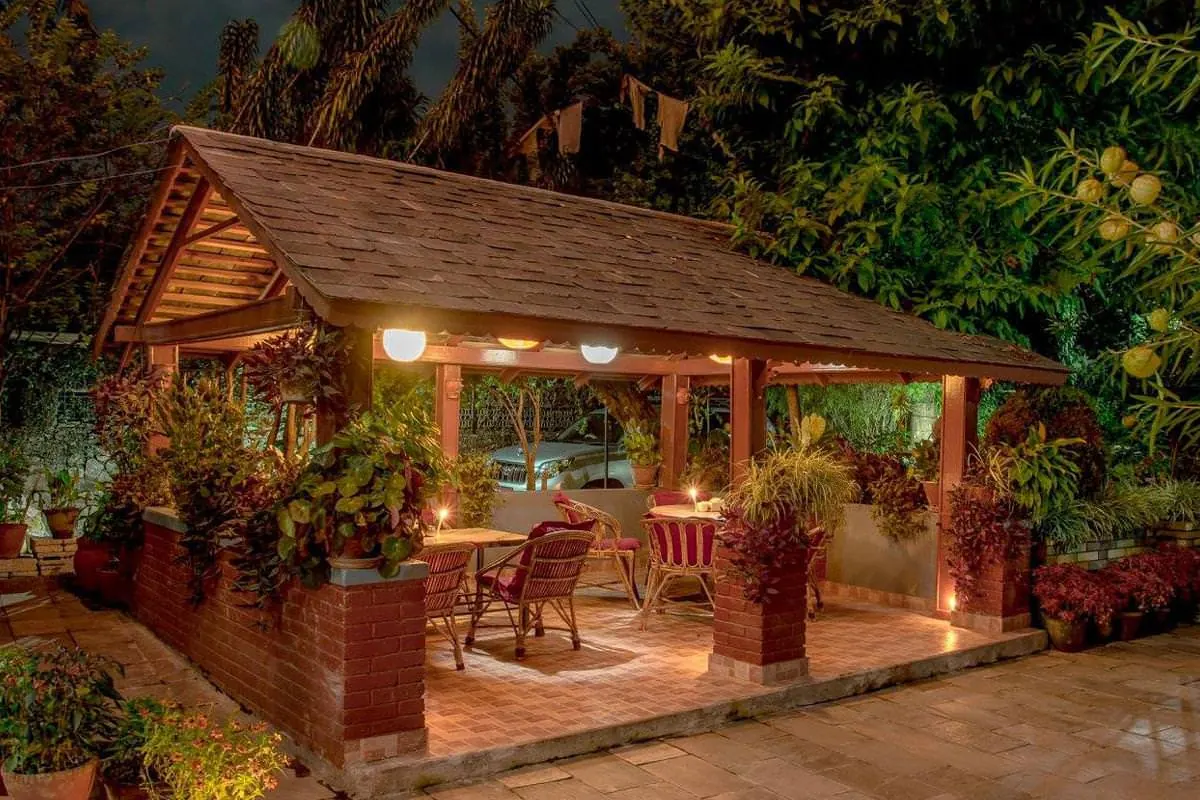 Wooden garden pavilion lit up at night