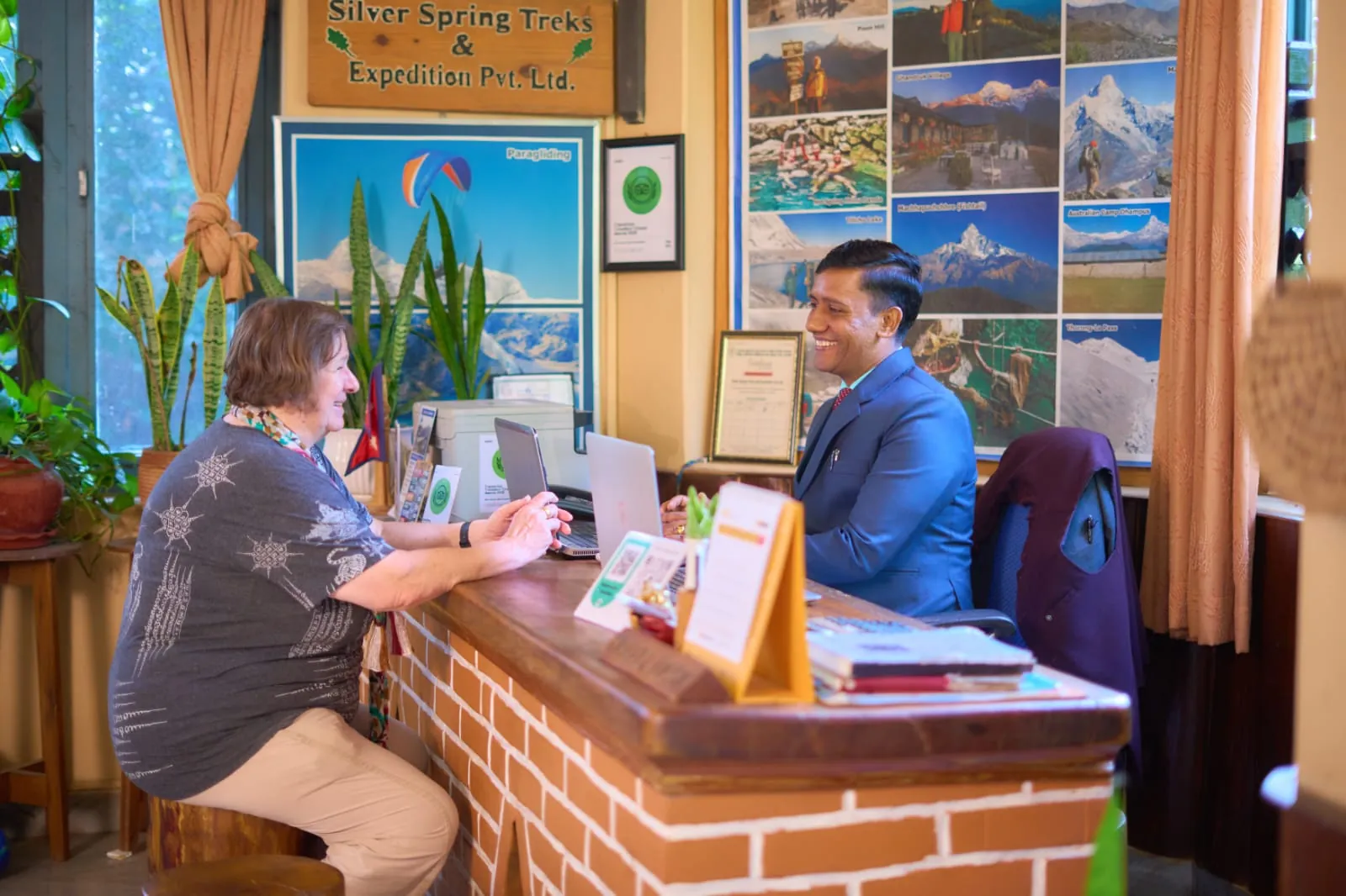 Our travel desk helping a guest plan her trek under the Annapurna posters